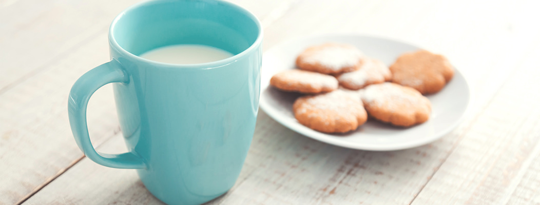 A glass of milk with cookies