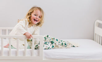 A toddle playing in her bed