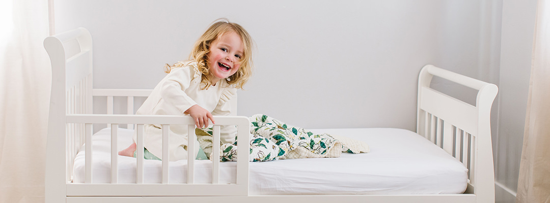 A toddle playing in her bed