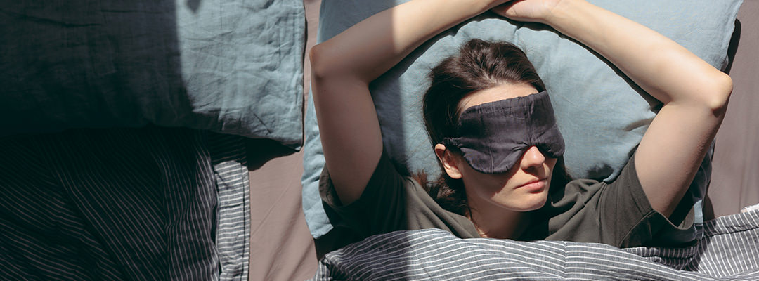 A woman sleeping with a mask on her eyes