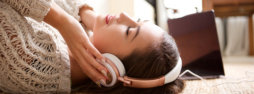 A young woman listening to music with the eyes closed