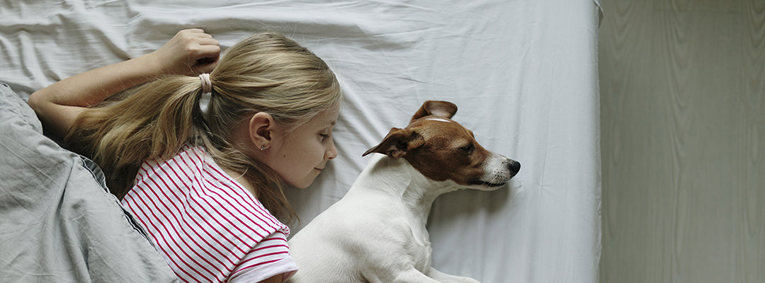 A woman sleeping with her dog