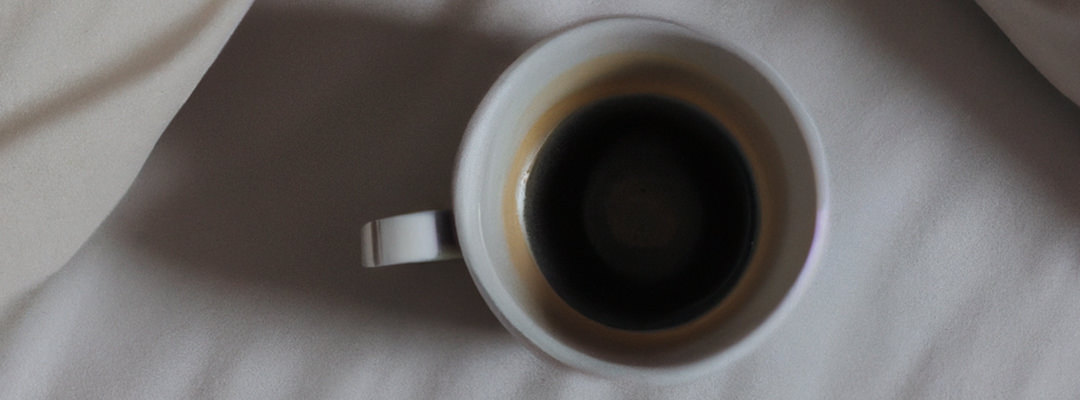 Cup of coffee on a bed